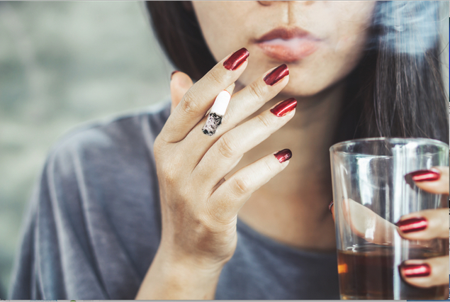 Bild auf dem eine Frau eine Zigarette raucht und Alkohol trinkt